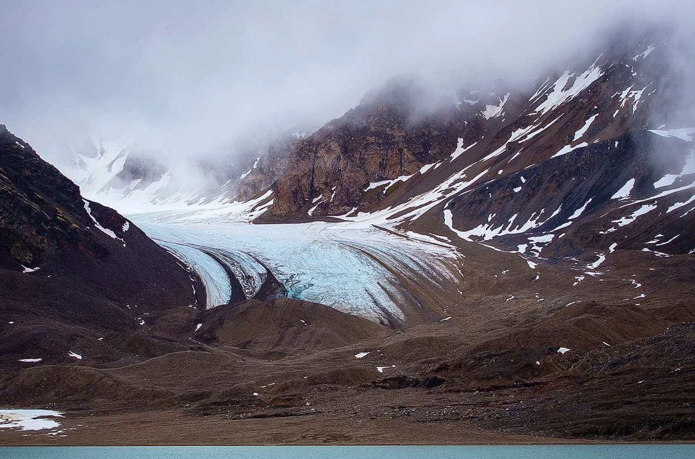 A glacier and terminal moraine at Tinayrebukta, Svalbard, Norway.